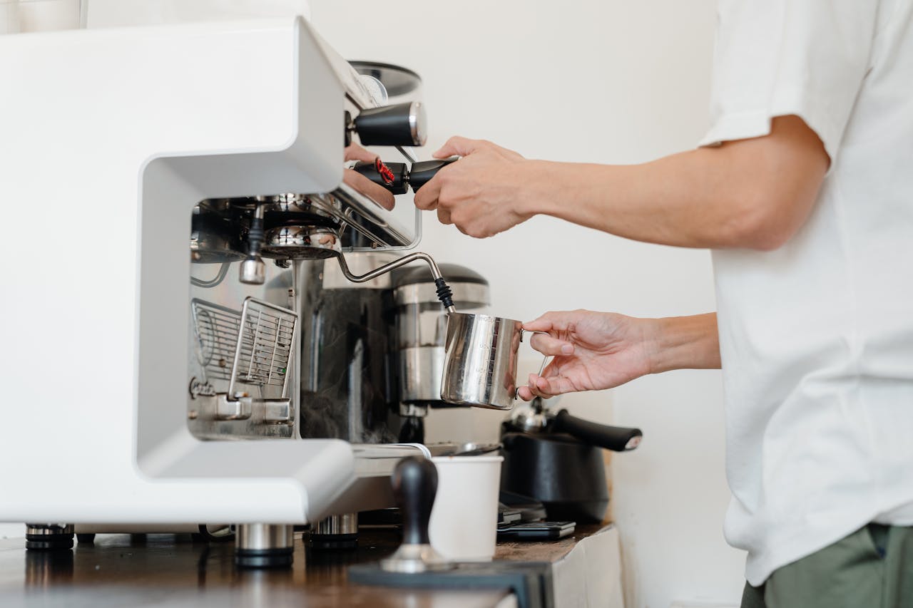 Best Coffee for French Press, What Quality You Seek? - CoffeeTimeUSA.com Close-up of a barista steaming milk using an espresso machine in a cafe setting.